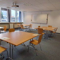 Großer Seminarraum mit Tischen und Stühlen für Gruppenarbeiten
