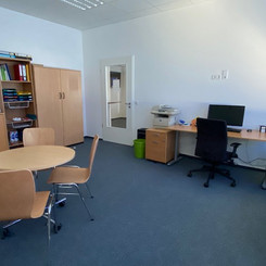 Büro mit Gesprächsbereich und PC-Arbeitsplatz.