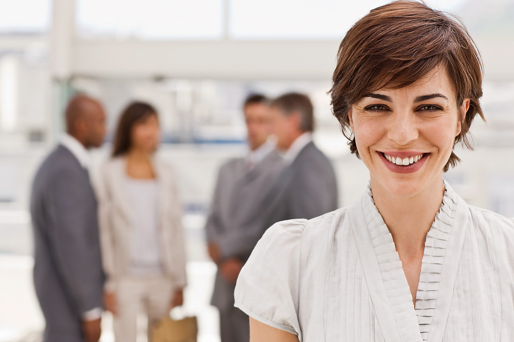 Happy businesswoman with colleagues in the background